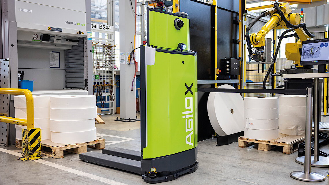 Transport robot moving a pallet with reels