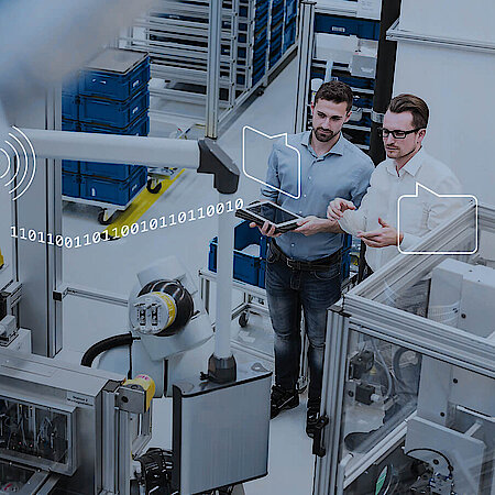 Software graphics lie over photo of two men looking at a machine.