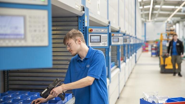 Ein Auszubildender zur Fachkraft für Lagerlogistik scannt ein Werkstück