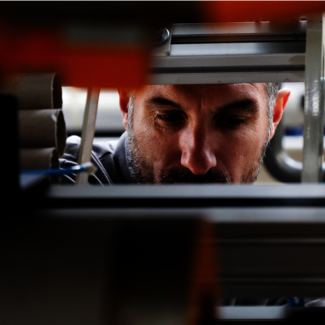 Face of a man is viewed through a machine.