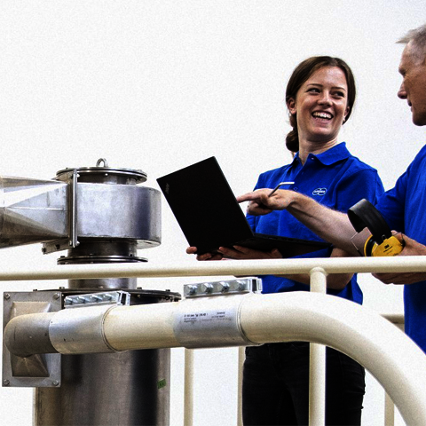 [Translate to English:] Zwei Körber Technologies Mitarbeiter stehen in der Produktionshalle.